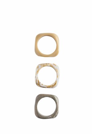 Drei quadratische Harzringe mit abgerundeten Kanten in Beige, Weiß mit braunen Wirbeln und grau marmorierten Farben, vertikal auf weißem Hintergrund angeordnet.