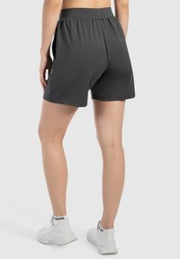 Donkergrijze shorts met een elastische tailleband en een relaxte pasvorm. Zacht, ademend materiaal zonder zichtbare patronen of accenten.