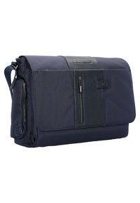 Borsa a tracolla navy con dettagli in tessuto e pelle. Presenta una pattina frontale, tasche con zip e una tracolla regolabile. Design strutturato.