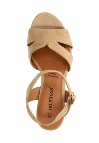 Beige suède sandaal met een memory foam binnenzool, voorzien van een kruisbandontwerp en een verstelbare enkelgesp. Zachte textuur en open teen.