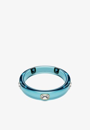 Transparante blauwe bangle van acryl, met rechthoekige heldere en smaragdgroene accenten aan de zijkanten. Gladde textuur.