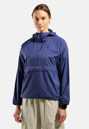 Marineblauer leichter Pullover mit Kapuze, halber Reißverschluss vorne, elastischen Bündchen und einer Brusttasche. Das Material wirkt glatt und wasserabweisend.