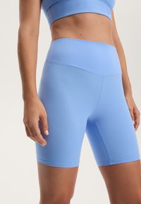 Svijetloplave visoke biciklističke kratke hlače izrađene od rastezljivog materijala, s bešavnom dizajnom i bez vidljivih dijelova ili uzoraka.