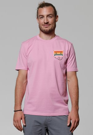 Rosa Baumwoll-T-Shirt mit einer Fronttaschenillustration eines Kassettenrekorders, das horizontale Streifen in Orange, Gelb und Blau zeigt.