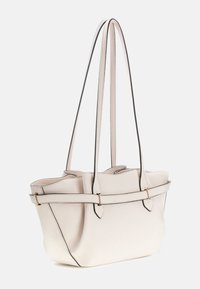 Cremefarbene Handtasche mit schwarzem Besatz, zwei langen Trägern, rechteckiger Form, strukturiertem Leder und einem zentralen dekorativen Riemen mit goldfarbenen Beschlägen.