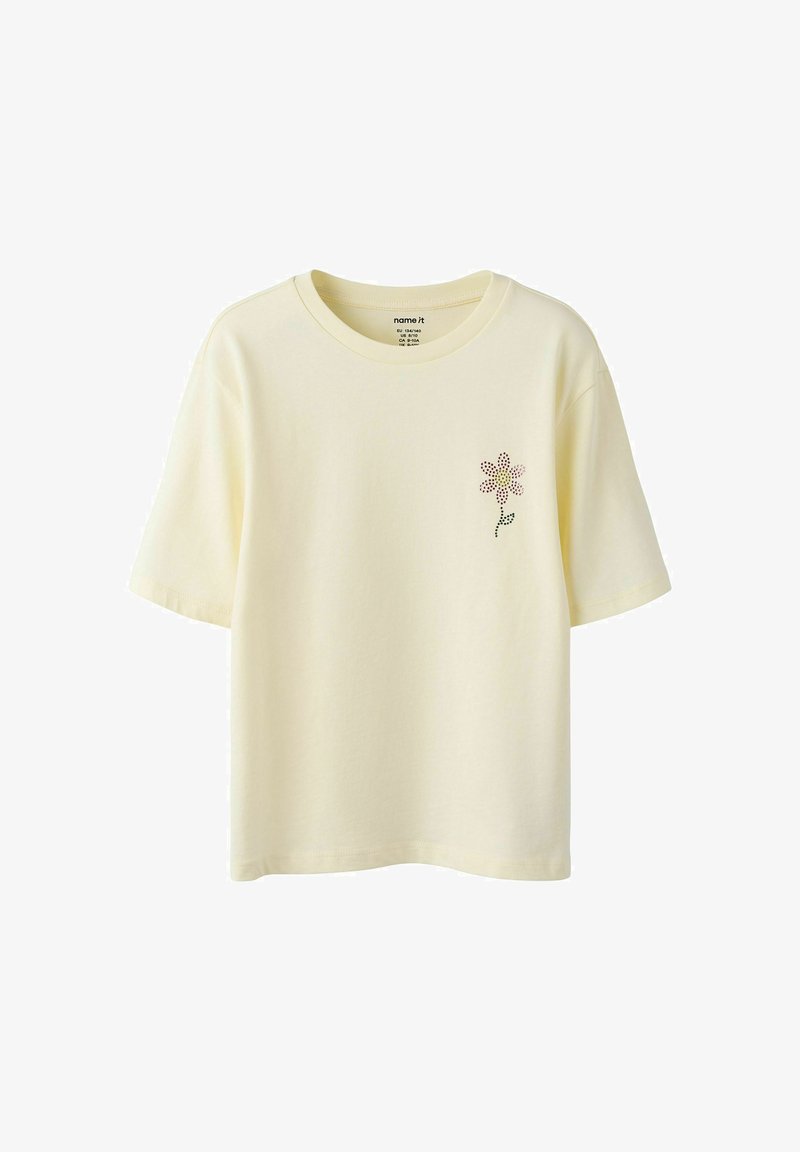 T-shirt jaune clair à manches courtes avec un petit motif de fleur en points sur la poitrine gauche et un col rond.