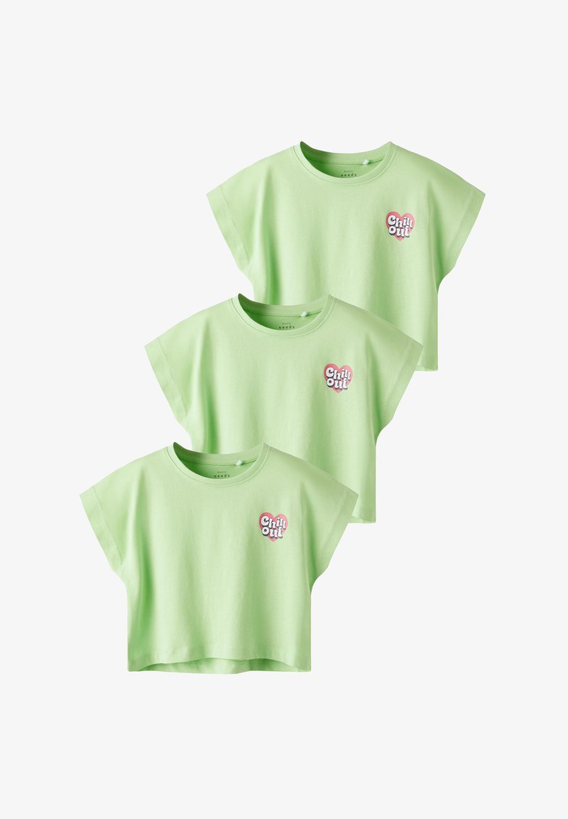 Drei kurzärmelige, kurz geschnittene T-Shirts aus hellgrüner Baumwolle mit einem "Chill Out" Herzlogo auf der linken Brust. Sanfte Textur.