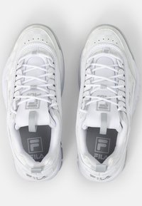 Scarpe sportive bianche con tomaia in materiale sintetico, chiusura con lacci, linguetta imbottita, dettagli grigi e suola in gomma testurizzata con un logo.