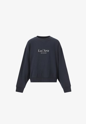 Mørk marineblå sweatshirt og joggers sæt lavet af en bomuldsblanding, med en rund hals og broderet tekst. Kombineret med hvide sneakers.