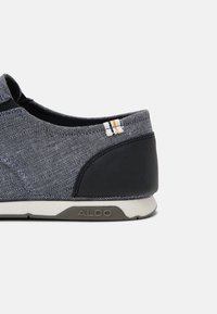 Šedá textilní nazouvací bota s temně námořnickým akcentem na patě, detail v bílých a zlatých pruzích a šedou gumovou podrážkou s nápisem "ALDO".