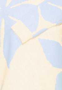 Neulottu villapaita, jossa teksturoitu kangas ja vaalean kermahtavat sekä vaaleansiniset abstraktit lehtikuvioinnit. Värilohkot luovat pehmeän visuaalisen kontrastin.