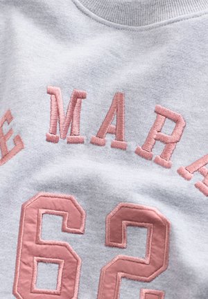 Lys grå sweatshirt med hævet pink broderi med teksten "62" og "MARA." Blødt stof med rund hals.