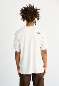 The North Face M VARSITY GRAPHIC RELAXED SS TEE - Triko s potiskem - white dune