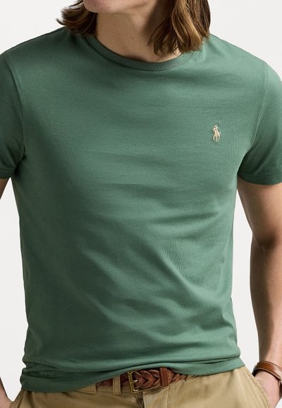 Green cotton t-shirt with a crew neckline and a subtle embroidered logo on the chest. Features a smooth, fitted texture.