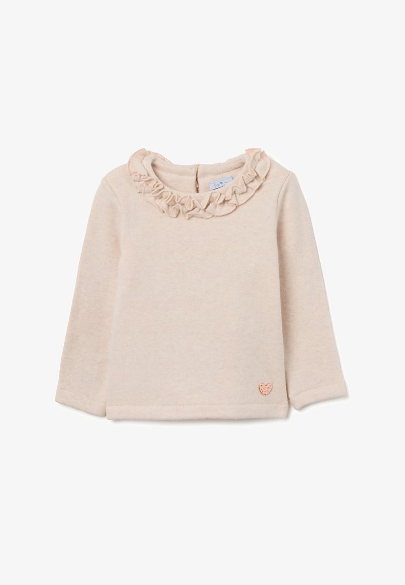 T-shirt bébé à manches longues couleur crème avec col volanté et petit emblème en forme de cœur près de l'ourlet inférieur.