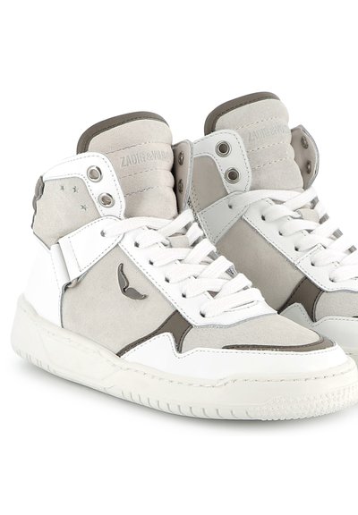 Baskets montantes en cuir blanc et daim gris, avec des œillets en métal, des semelles texturées et un logo sur le côté.