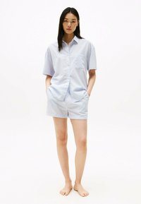 Blauw-wit gestreepte shirt met korte mouwen en een borstzak, gecombineerd met bijpassende shorts, gemaakt van lichtgewicht stof, geschikt voor vrijetijdskleding.