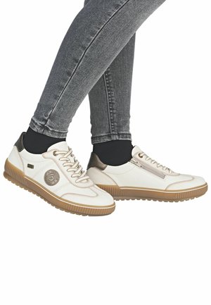 Białe sneakersy z tanowymi gumowymi podeszwami, fakturowanymi panelami, metalicznymi akcentami i zdobniczym logo. Zaprojektowane z myślą o komforcie i codziennym noszeniu.
