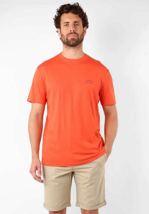 T-shirt orange vif en tissu lisse. Modèle à col rond avec des manches courtes et un petit logo imprimé en marine sur la poitrine.