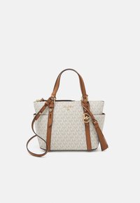 Texturierte beige Handtasche mit Monogramm-Muster, braunen Lederakzenten, doppelten Henkeln und einem abnehmbaren Schultergurt. Details in Goldoptik.