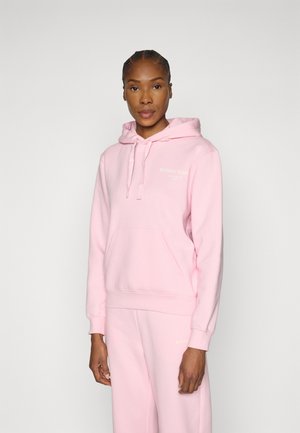 Ροζ φούτερ με κουκούλα από απαλό βαμβάκι, με τσέπη καγκουρό, κορδόνι στην κουκούλα και διακριτικές λεπτομέρειες λογοτύπου στο στήθος, συνδυασμένο με παντελόνια που ταιριάζουν.