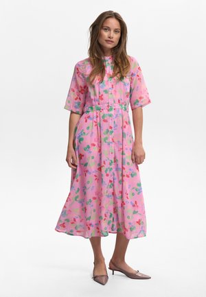Bloemene midi-jurk van doorschijnende roze stof met korte mouwen, knoopsluiting aan de voorkant en een striktaille. Bevat rode, groene en blauwe bloempatronen.