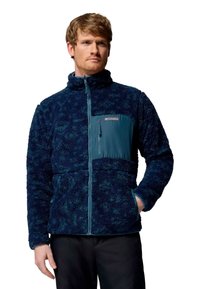 Giacca in fleece blu con zip frontale, colletto alto e pannello centrale in teal a contrasto. Presenta un tessuto testurizzato e tasche laterali.