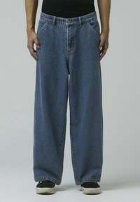 Blue denim wide-leg jeans with a high waist, featuring five pockets, contrasting stitching, and a button-fly closure.
