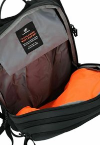 Zwarte rugzak met een grijze binnenkant, voorzien van een oranje sectie, een stoffen label met tekst en een ritsopening aan de bovenkant.