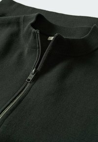 Pull en maille noire avec une courte fermeture éclair argentée et un col montant côtelé, présenté en gros plan sur fond blanc.