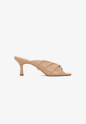 Bézs színű bőrből készült nyitott orrú papucsok redőzött kialakítással, keskenyedő sarokkal és sima textúrával. Arany díszítés az oldalon.