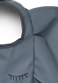 Grå vandtæt stofpose med rund udskæring til håndtag og sort vippes design. Glat overflade med stikninger på kanterne og en fleksibel form.