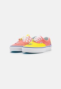 Baskets colorées avec une tige en daim rose et mesh jaune, motif damier, broderie d'un personnage de dessin animé notable, semelles blanches.