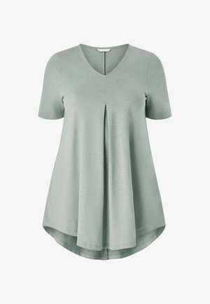 T-shirt tunica a maniche corte e scollo a V in morbido tessuto verde chiaro, con una piega centrale e un orlo arrotondato per maggiore fluidità.