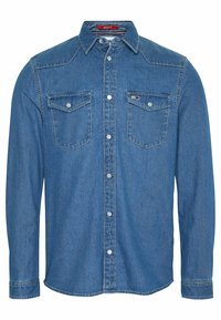 Jeansskjorta i medelblått, med spetskrage, långa ärmar, två bröstfickor och vita knappar. Rakt snitt med sömdekor.