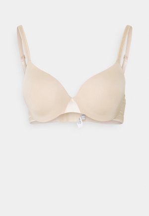 Beige padded bra with smooth fabric, adjustable straps, and a simple design. Features a seamless center and a tag on the inner side.