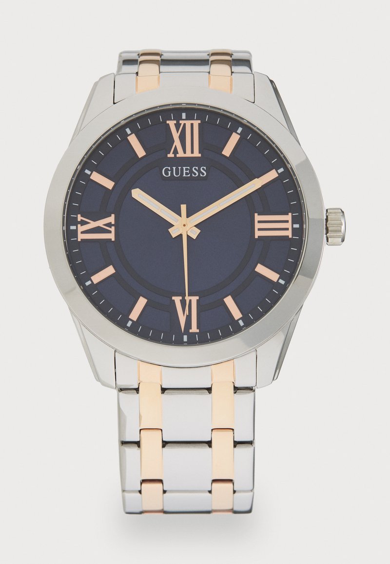 Reloj de acero inoxidable con una esfera azul marino, números romanos en oro rosa y una pulsera metálica bicolor que presenta eslabones alternos de plata y oro.