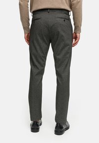 Pantalones grises con un patrón, confeccionados con una tela texturizada. Presentan dos bolsillos traseros con cierre de botón y un diseño de pierna recta.