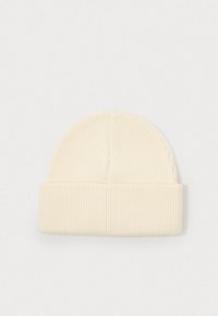 Crème gebreide beanie met een omgeslagen boord, voorzien van een verticale ribbelstructuur en een afgeronde bovenkant. Simpel en neutraal ontwerp.