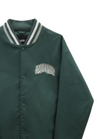 Vihreä satiininen bomberitakki, jossa on raidallinen ribbikuitukaulus ja nappisuljenta. Takissa on brodeerattu "VANS"-logo tyylitellyllä fontilla.