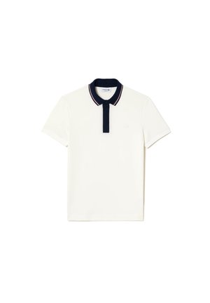 Polo blanc à manches courtes avec col et patte de boutonnage bleu marine, bordure rouge et blanche sur le col et logo brodé discret sur la poitrine.