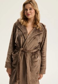 Brązowy, pluszowy szlafrok z kapturem, szerokimi rękawami i wiązanym w pasie. Posiada dwie przednie kieszenie oraz miękkie, teksturowane wykończenie.