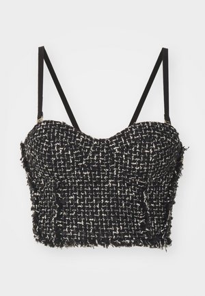 Black and white tweed crop top with a fitted bodice, thin black straps, and frayed edges. The fabric has a textured, woven pattern.