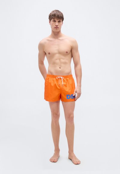 Φωτεινά πορτοκαλί μαγιό βερμούδα με λευκό κορδόνι, με μπλε λογότυπο "DSU" στο αριστερό πόδι. Κατασκευασμένο από απαλό, ελαφρύ υλικό.
