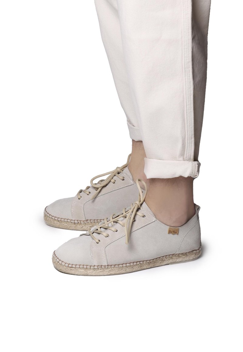 Scarpe in suede beige con design allacciato, dotate di una suola in juta cucita e di un piccolo etichetta del marchio sul lato. Punta arrotondata e stile a taglio basso.
