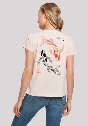 Hellrosa T-Shirt mit kurzen Ärmeln, das auf der Rückseite mit schwarzen und orangen Koi-Fisch-Motiven sowie japanischem Text und einem roten Stern-Akzent gestaltet ist.