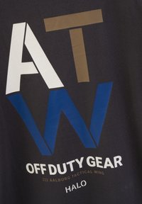 Svart t-shirt i tyg med djärv, flerfärgad text: "AT W" i vitt, brunt och blått; "OFF DUTY GEAR" och "HALO" i vitt nedanför.