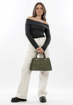 Green handbag with a smooth texture, rectangular shape, and decorative stitching. Model wears a dark off-the-shoulder top and light pants.