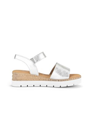 Sandale argentée à bout ouvert avec bride à la cheville, semelle intérieure rembourrée, talon compensé à texture liège et semelle extérieure en caoutchouc blanc pour un usage décontracté.