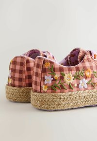 Espadrilles en vichy rose avec broderie florale, semelles en corde de jute et doublure douce. Forme arrondie avec un design décolleté et un matériel minimal.
